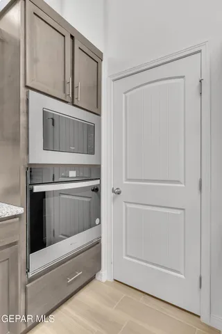 a kitchen with white cabinets and oven