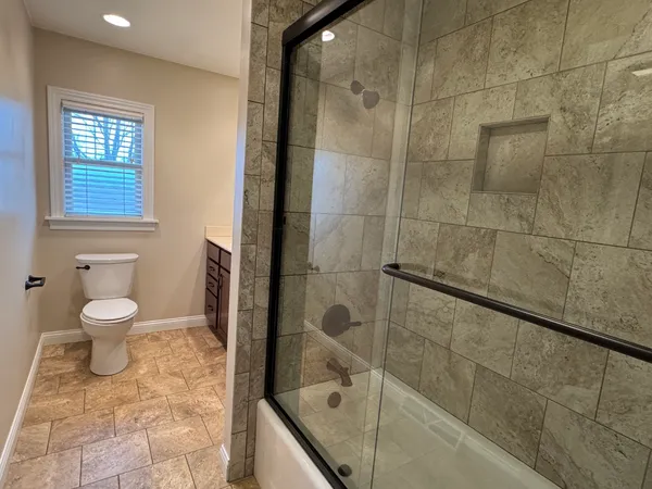 a bathroom with a toilet and a shower