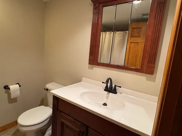 a bathroom with a sink a toilet and mirror