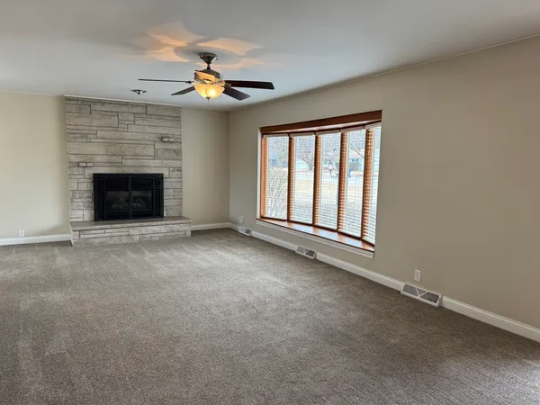 a view of an empty room with a fireplace and a window