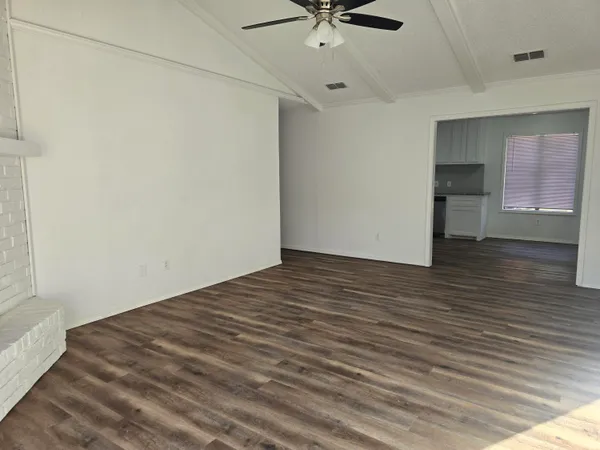 a view of a room with wooden floor and ceiling fan