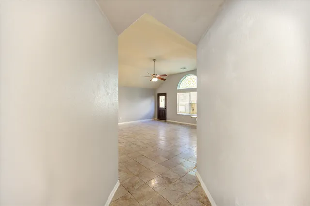 a view of a room with a stylish ceiling fan and entryway