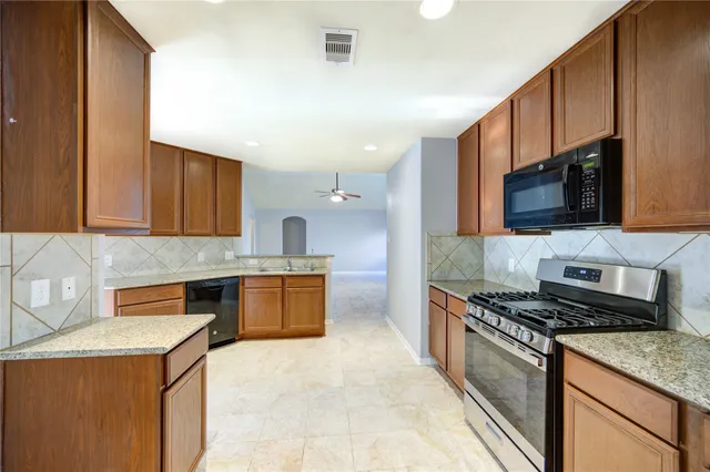 a kitchen with stainless steel appliances a sink stove and microwave