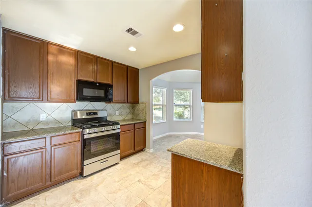 a kitchen with a sink a stove and microwave