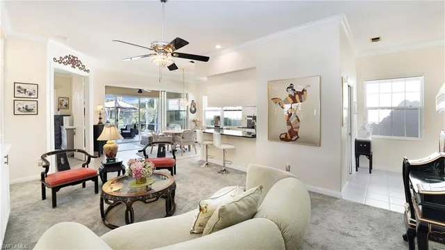 a living room with furniture kitchen view and a large window