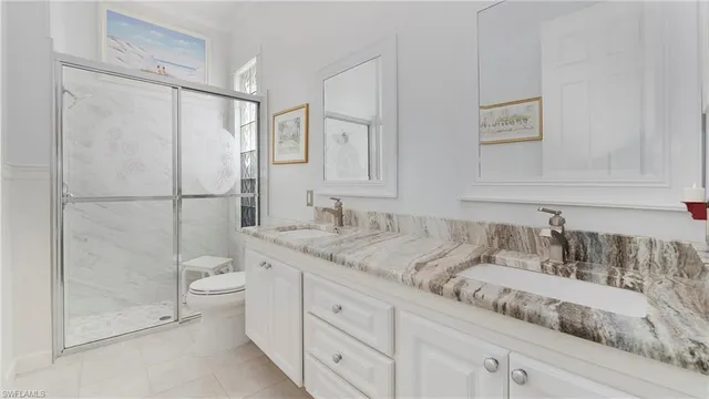 a bathroom with a granite countertop sink a toilet and shower