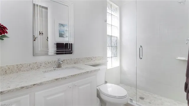 a bathroom with a granite countertop sink toilet and shower