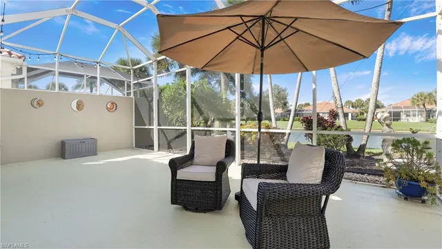a view of a patio with couches chairs under an umbrella