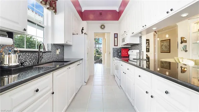 a large white kitchen with stainless steel appliances
