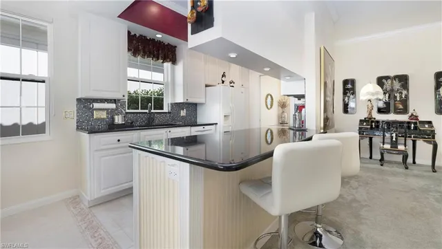 a kitchen with stainless steel appliances granite countertop a sink and a refrigerator