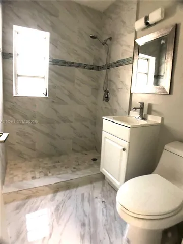 a white toilet sitting next to a bathroom sink