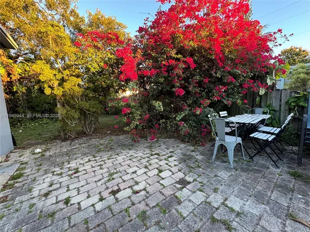 a view of a table and chairs in back yard of the house