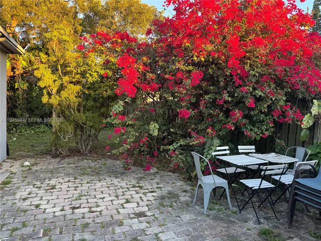 a backyard of a house with table and chairs