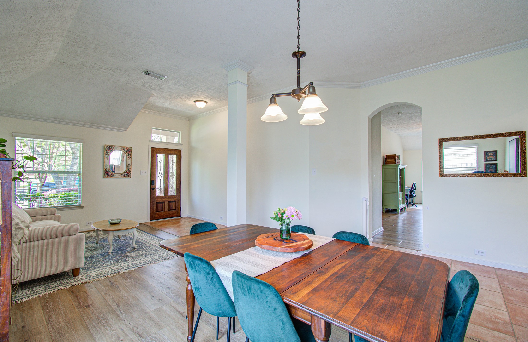 20007 Alcea Court Spring, TX 77379 - Photo 5 of 36 This welcoming home features an open living and dining area with abundant natural light, elegant wood flooring, and a cozy seating nook. The dining area is accented by a stylish light fixture, creating a perfect space for entertaining.