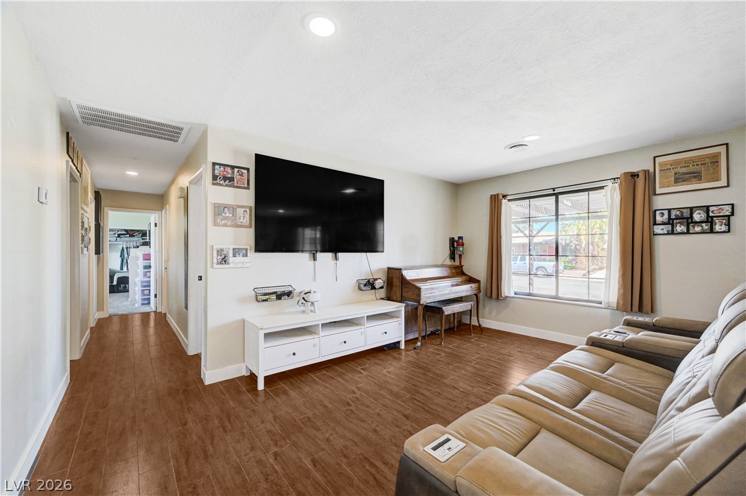 1331 Pinto Road Boulder City, NV 89005 - Photo 12 of 46 Rich wood flooring grounds this living space, offering views of the neighborhood from a well-sized window.