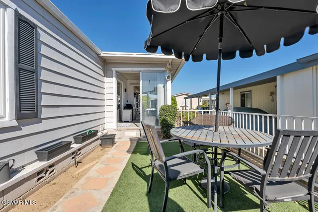 a view of a patio with a table and chairs under an umbrella