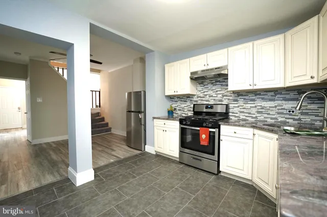 a kitchen with stainless steel appliances granite countertop a refrigerator and a stove