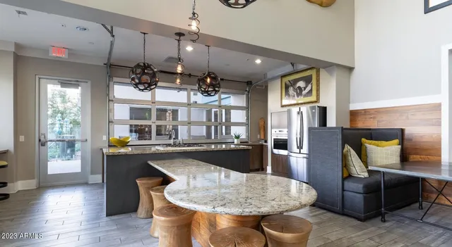 a living room with stainless steel appliances furniture a rug and a large window