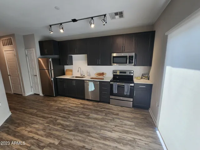 a kitchen with stainless steel appliances a refrigerator and a stove top oven