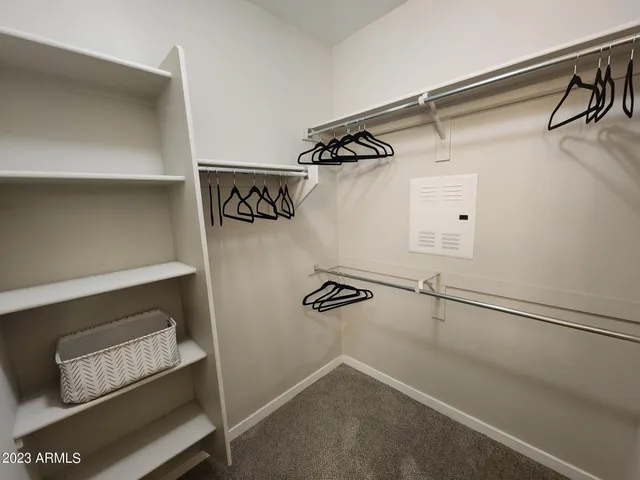 a view of walk in closet with clothes and shoes