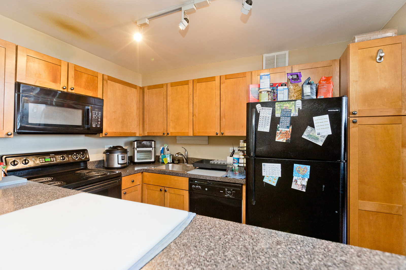 655 West Irving Park Road, Unit 2512 Chicago, IL 60613 - Photo 4 of 18 a kitchen with granite countertop a refrigerator stove top oven and sink