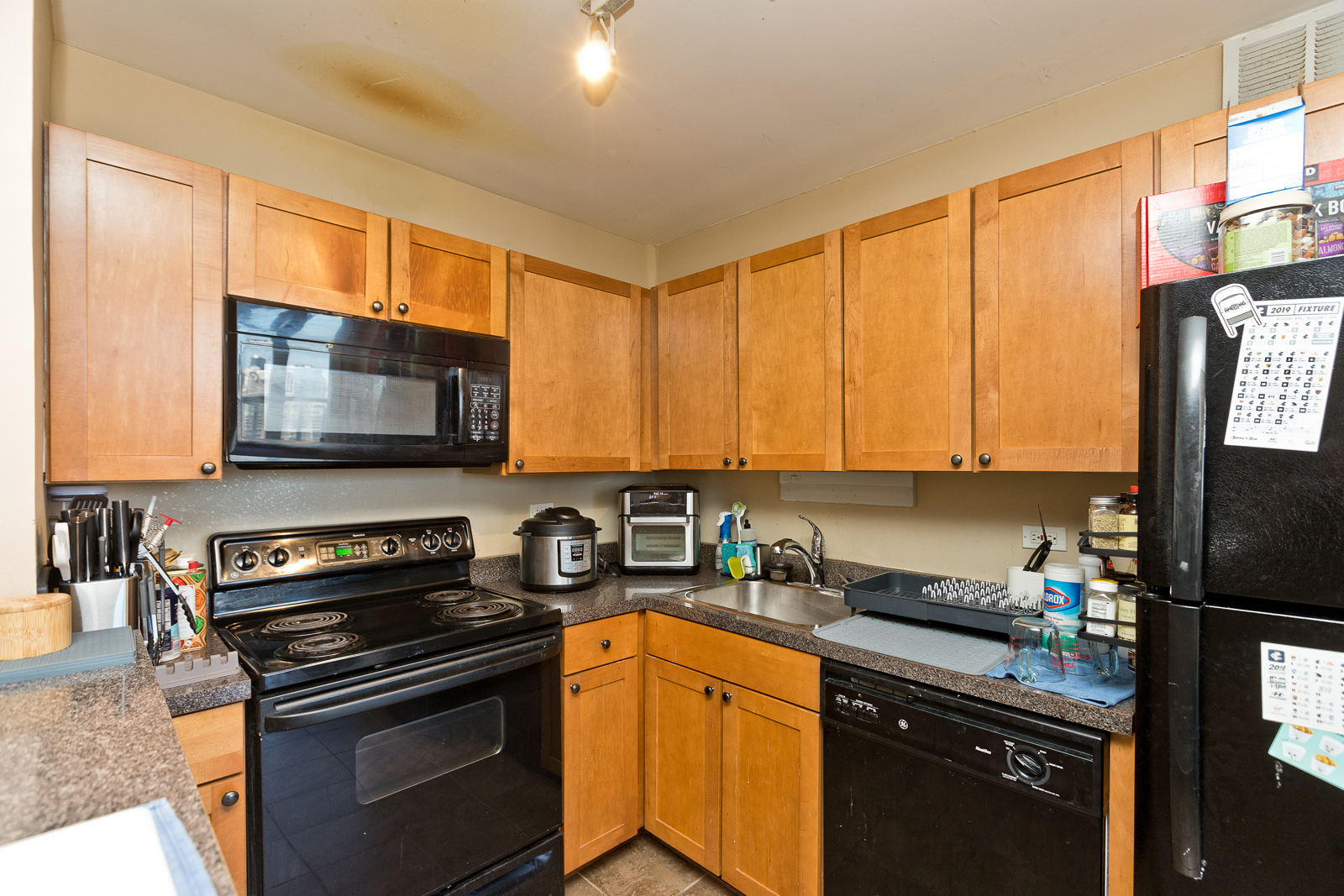 655 West Irving Park Road, Unit 2512 Chicago, IL 60613 - Photo 5 of 18 a kitchen with a stove a sink and a microwave