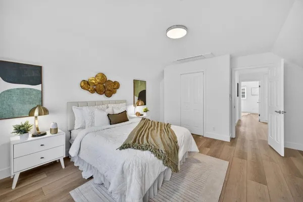 a bedroom with a bed and painting on the wall