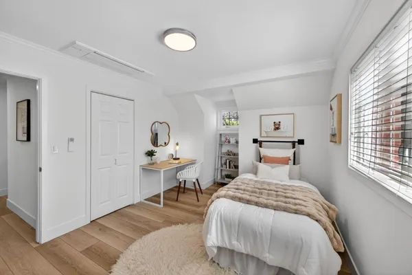 a bedroom with a bed a table and painting on the wall