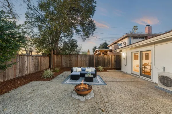 a backyard of a house with barbeque oven and outdoor seating