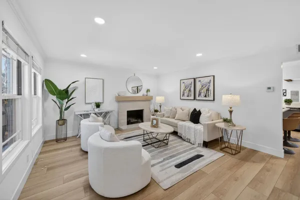 a living room with furniture a fireplace and a potted plant
