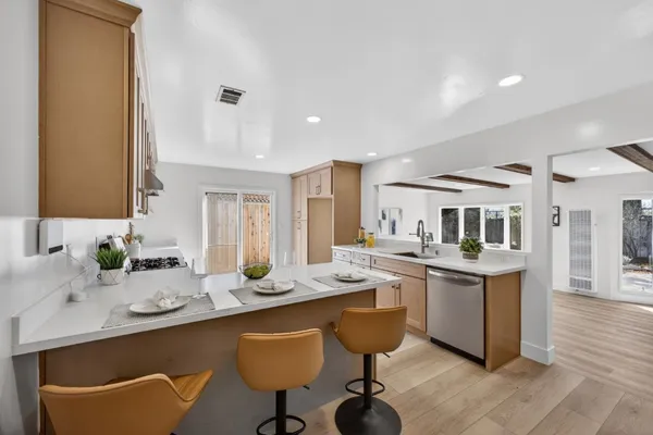 a kitchen with a sink and chairs