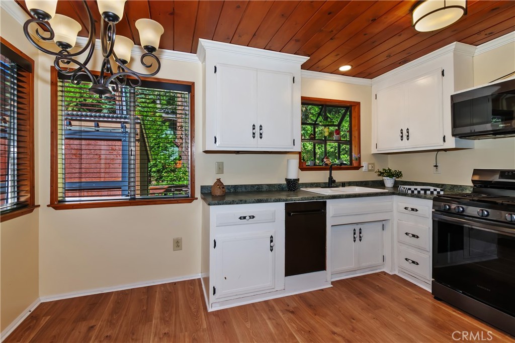 863 Oak Road Lake Arrowhead, CA 92385 - Photo 12 of 42 a kitchen with stainless steel appliances granite countertop a stove a sink and a microwave