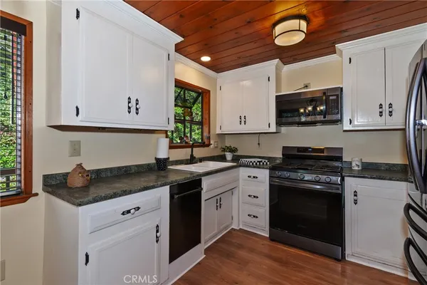 a kitchen with stainless steel appliances granite countertop a stove a sink and a microwave