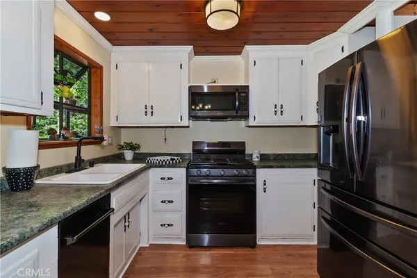 a kitchen with granite countertop a refrigerator stove and sink