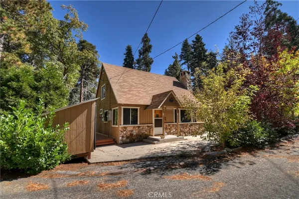 a front view of a house with a tree