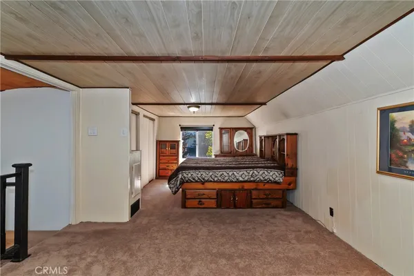 a spacious bedroom with a bed and a dresser
