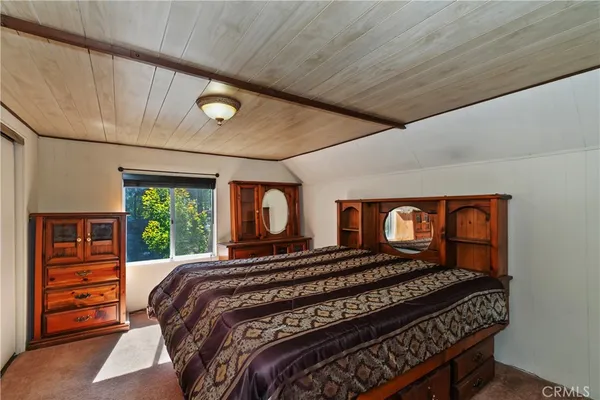 a bedroom with a bed next to a window