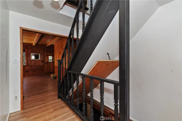 a view of a hallway with wooden floor and staircase