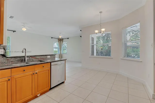 a kitchen with granite countertop a sink and white cabinets