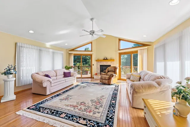 a living room with furniture fireplace and a large window
