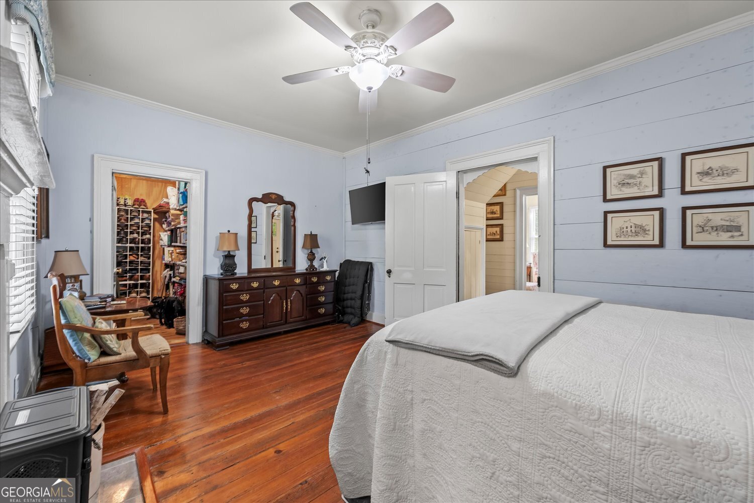 6644 East Cadley Road Norwood, GA 30821 - Photo 10 of 53 a spacious bedroom with a bed a dresser and a chandelier