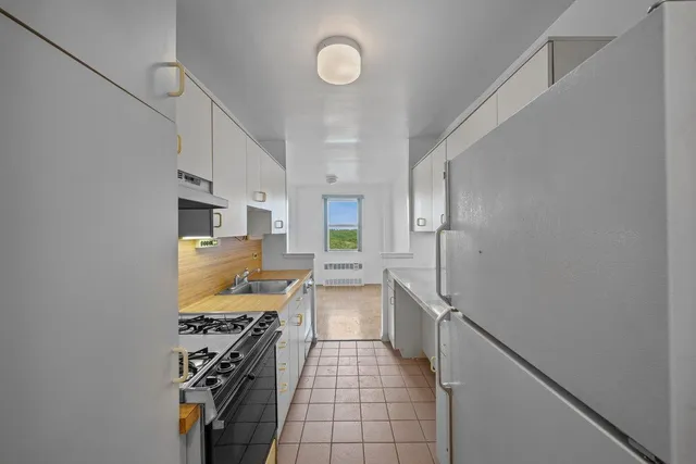 a kitchen with granite countertop a sink stove and cabinets