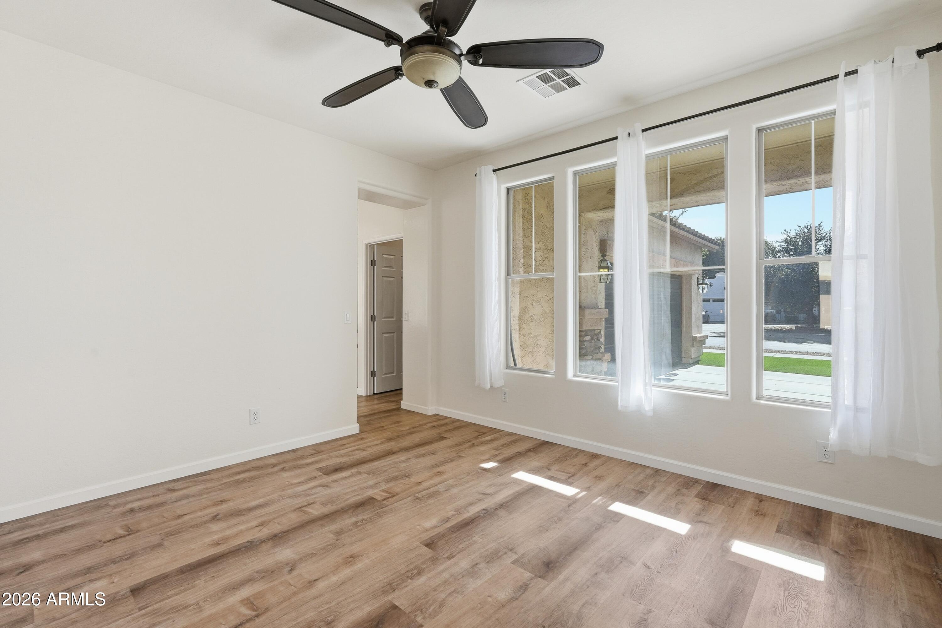 19760 East Mayberry Road Queen Creek, AZ 85142 - Photo 11 of 71 a view of an empty room with a window and wooden floor