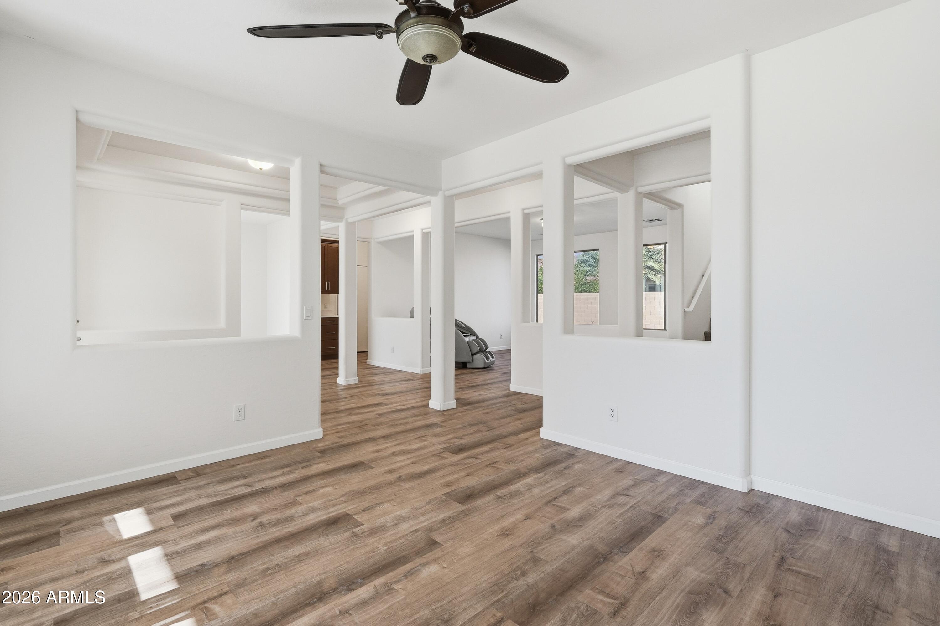 19760 East Mayberry Road Queen Creek, AZ 85142 - Photo 13 of 71 a view of an empty room with wooden floor and a ceiling fan