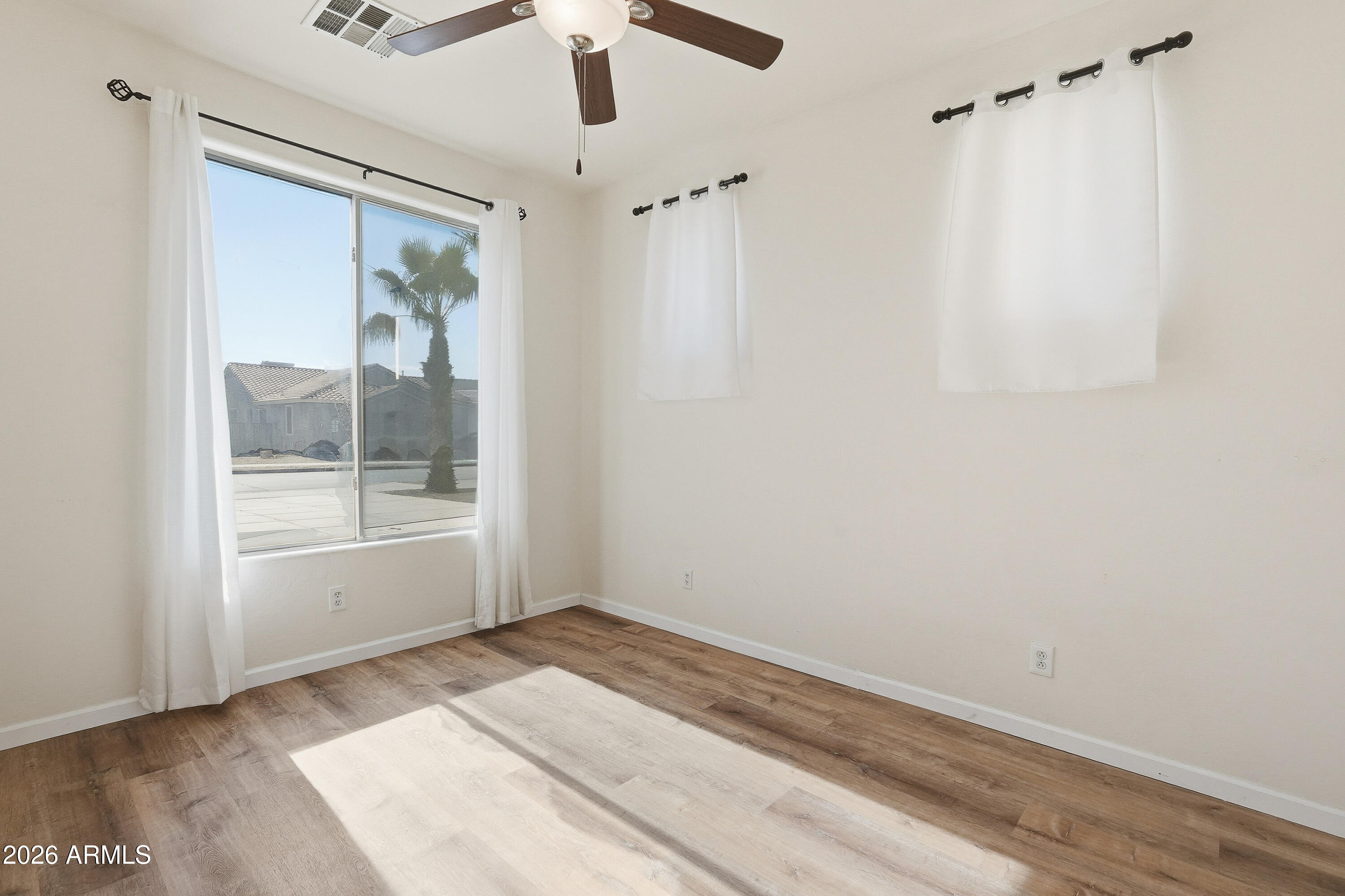 19760 East Mayberry Road Queen Creek, AZ 85142 - Photo 14 of 71 a view of empty room with wooden floor and fan