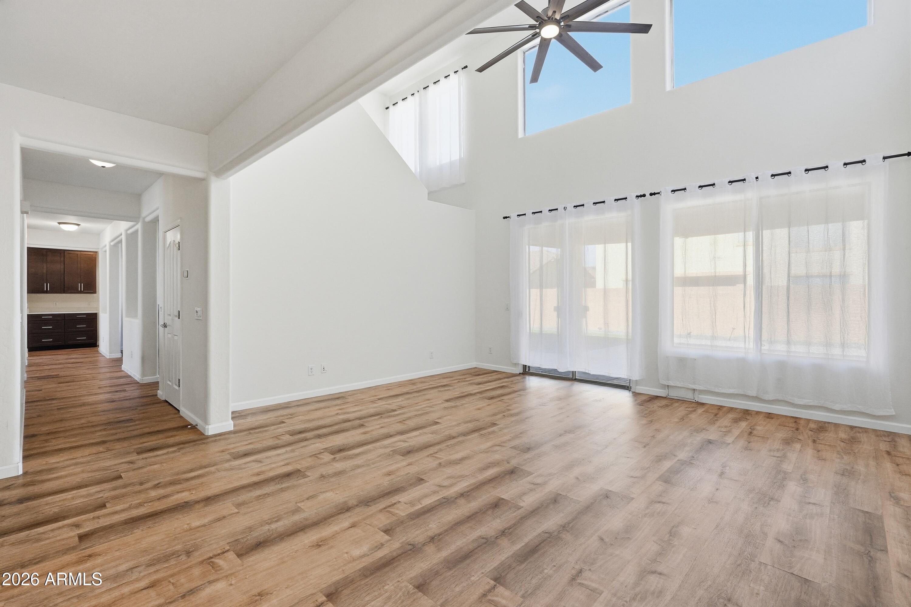 19760 East Mayberry Road Queen Creek, AZ 85142 - Photo 19 of 71 a view of an empty room with wooden floor and a ceiling fan