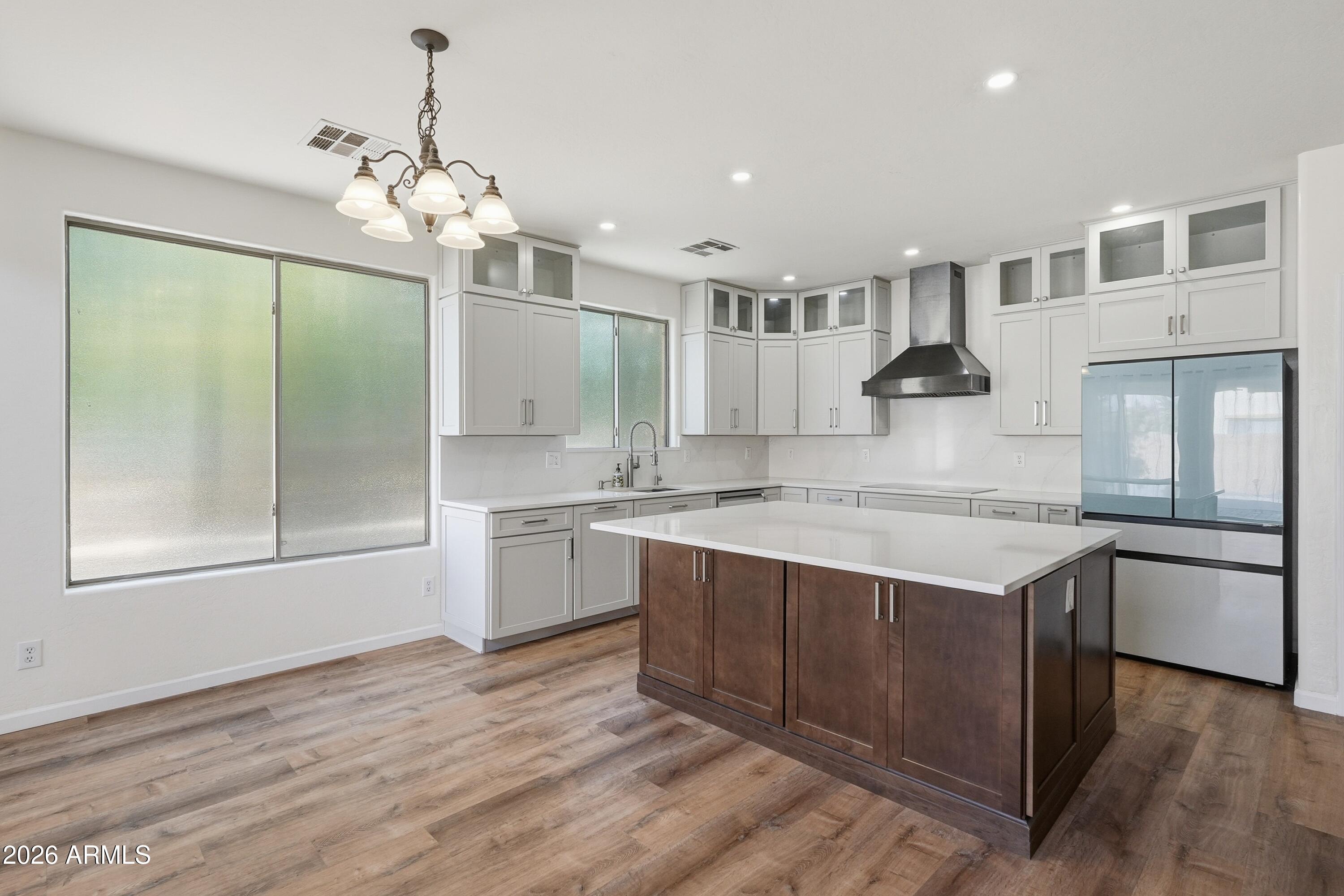 19760 East Mayberry Road Queen Creek, AZ 85142 - Photo 26 of 71 a large kitchen with stainless steel appliances granite countertop a sink and dishwasher a stove with wooden floor