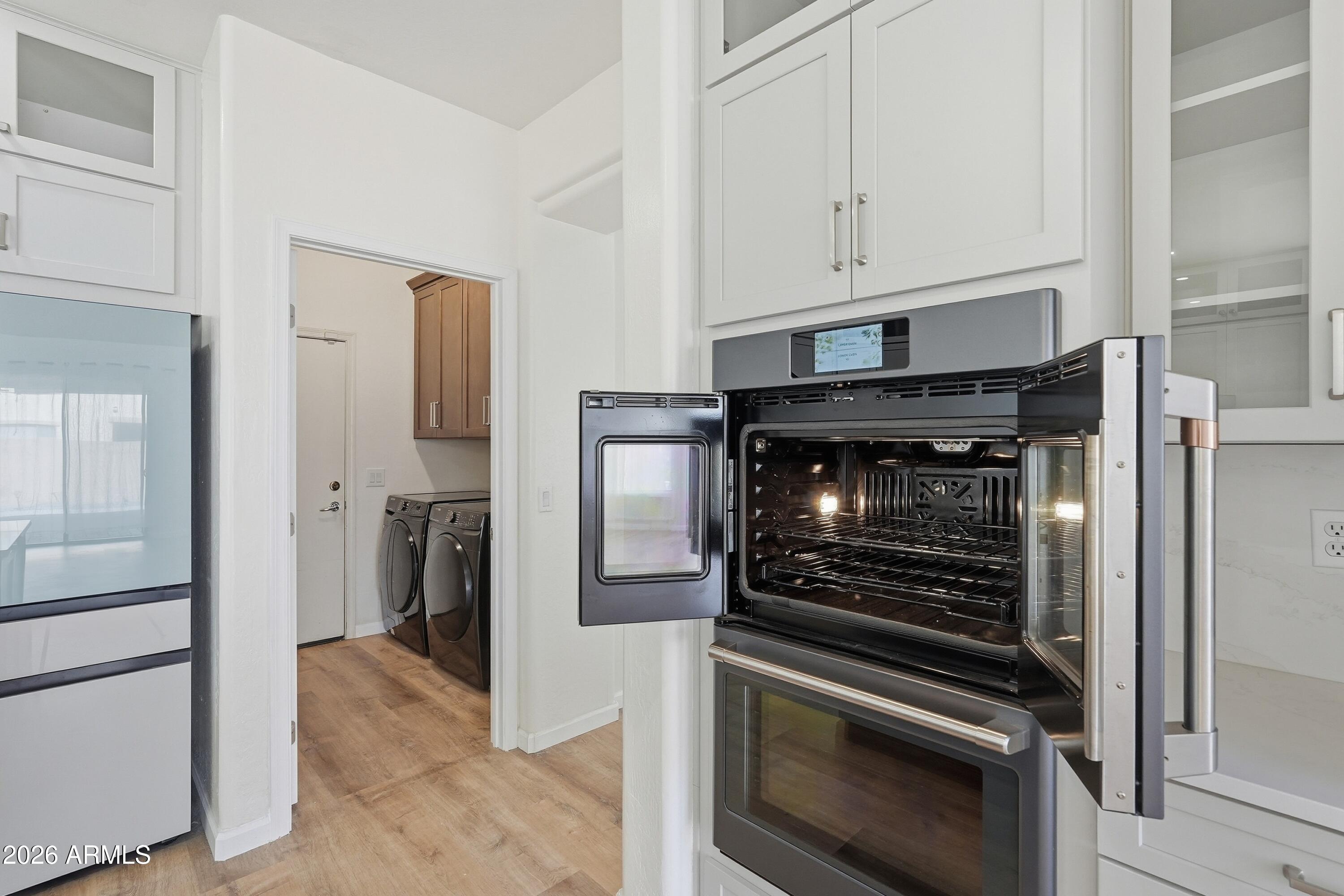 19760 East Mayberry Road Queen Creek, AZ 85142 - Photo 33 of 71 a kitchen with white cabinets and stainless steel appliances