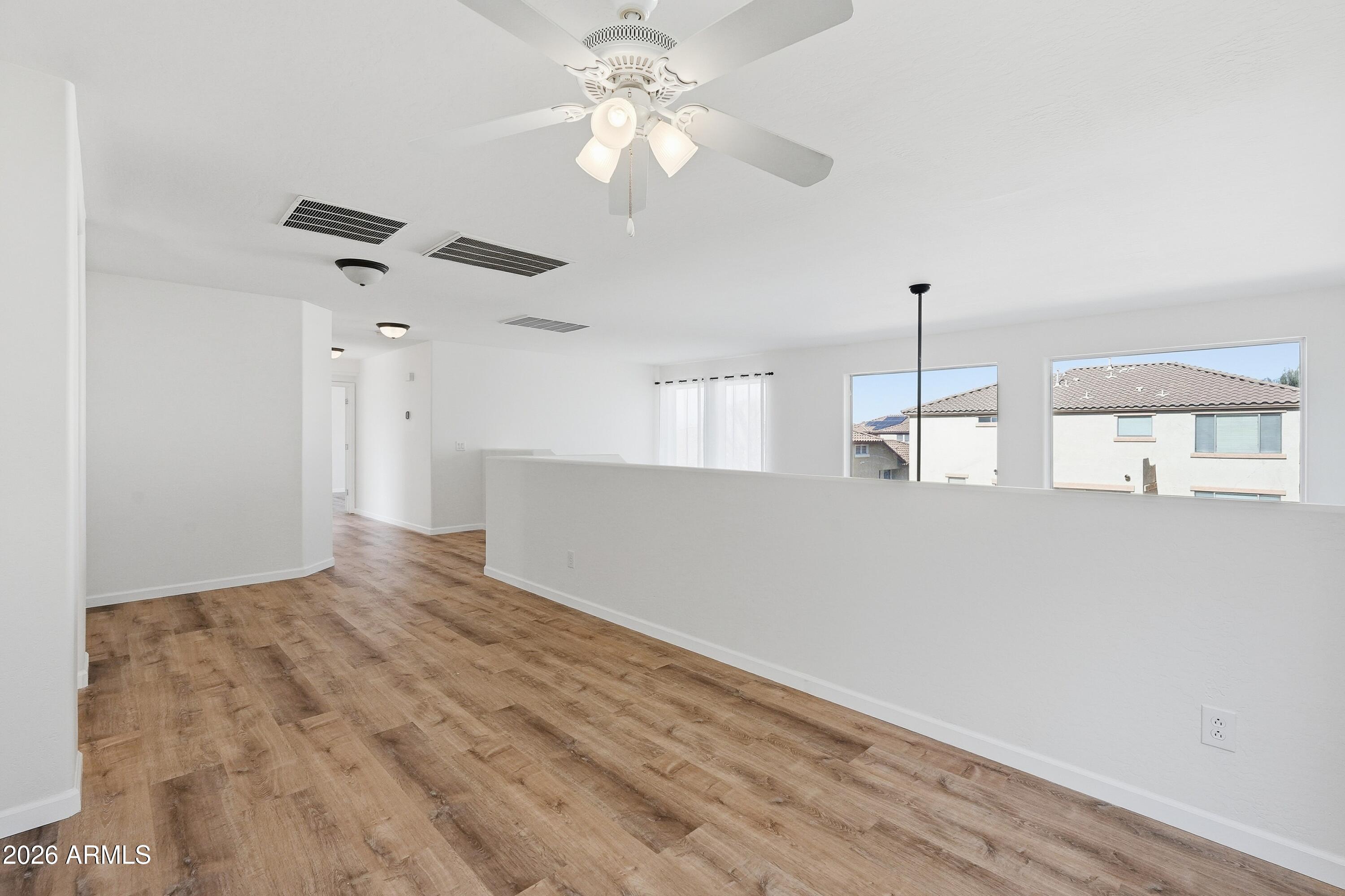 19760 East Mayberry Road Queen Creek, AZ 85142 - Photo 36 of 71 a view of an empty room with chandelier fan and wooden floor
