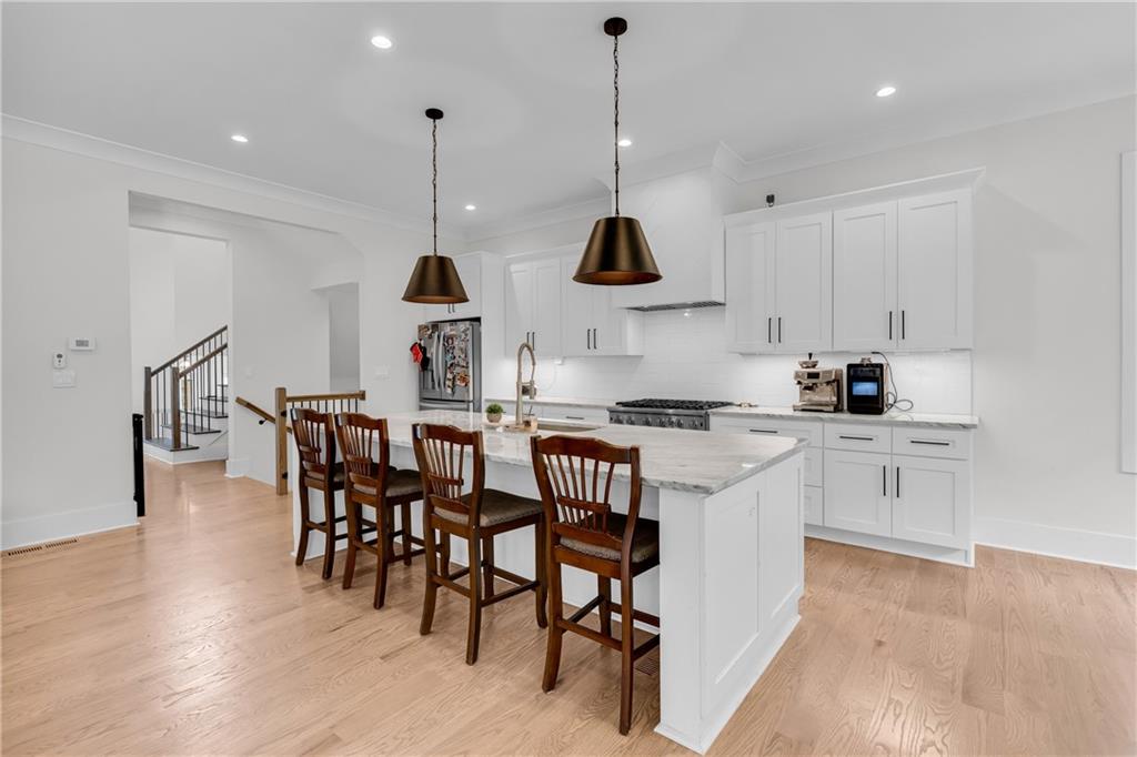 1141 Druid Fields Court Decatur, GA 30033 - Photo 6 of 35 a kitchen with stainless steel appliances granite countertop a stove a sink a dining table and chairs with wooden floor